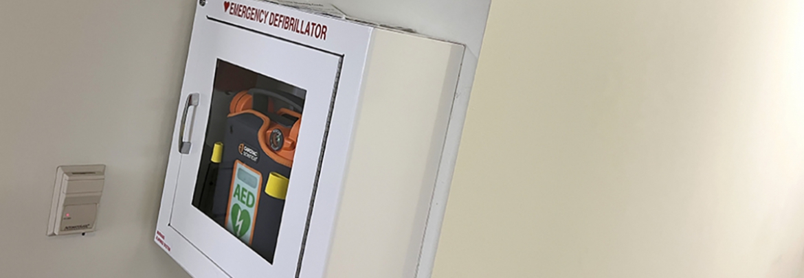 An AED box hangs on a wall